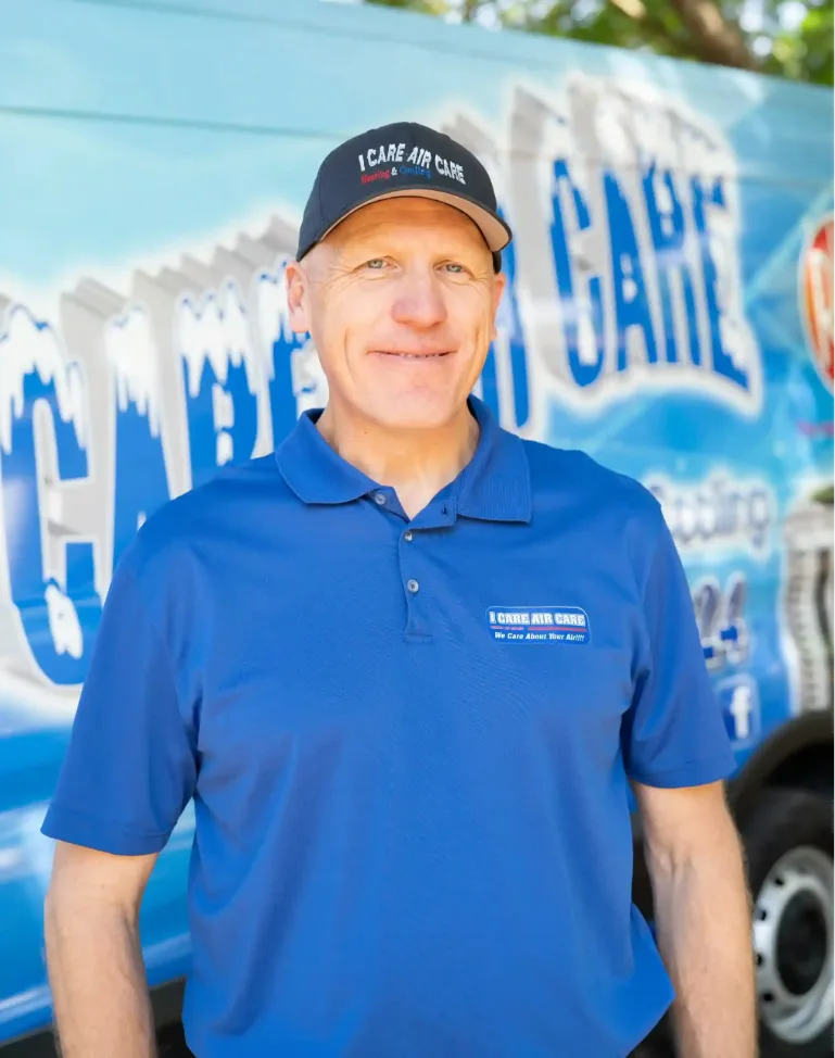 Tim Hawk, owner of I Care Air Care, smiling at his desk in Wesley Chapel, FL