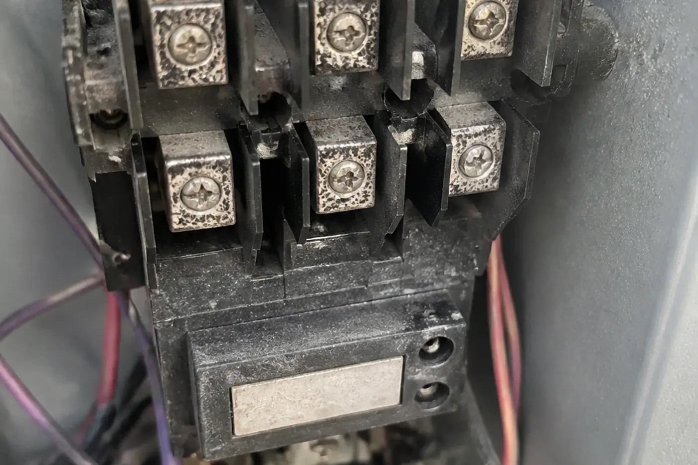 Pitted AC contactor contacts inside an outdoor condenser